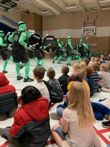 The Green Man Group performing for the students