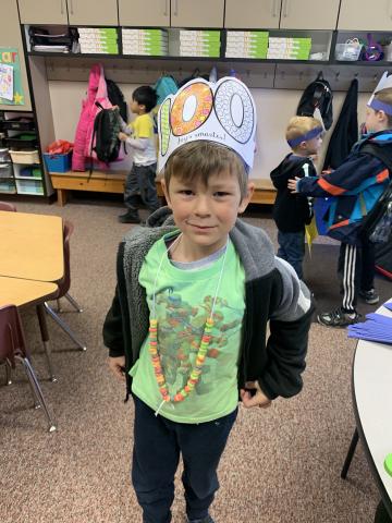 A student showing off his 100 days hat and necklace.