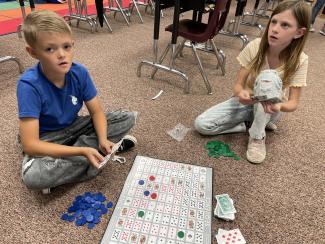 2 students playing Sequence.